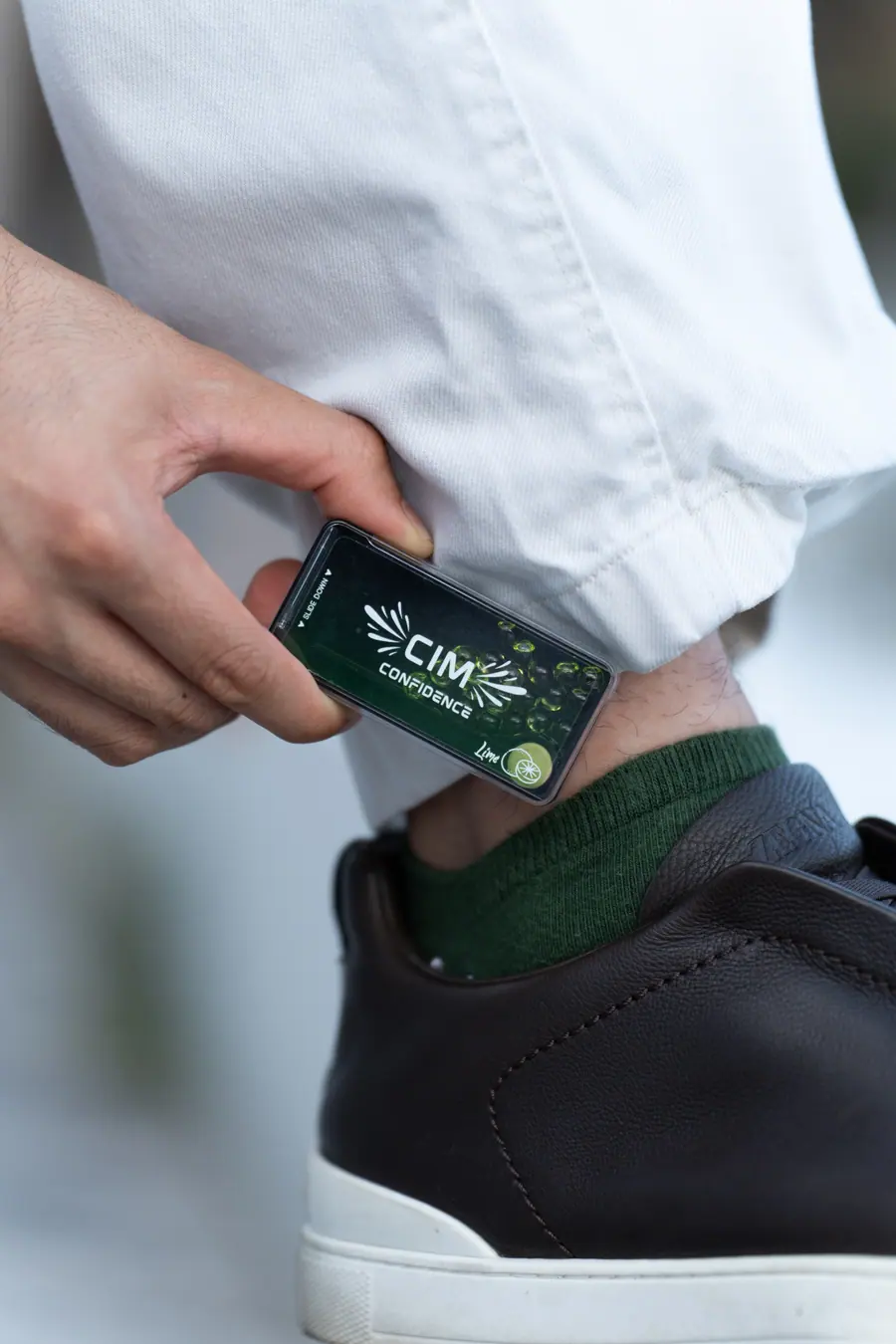 A lime CIM case being taken from a trouser pocket